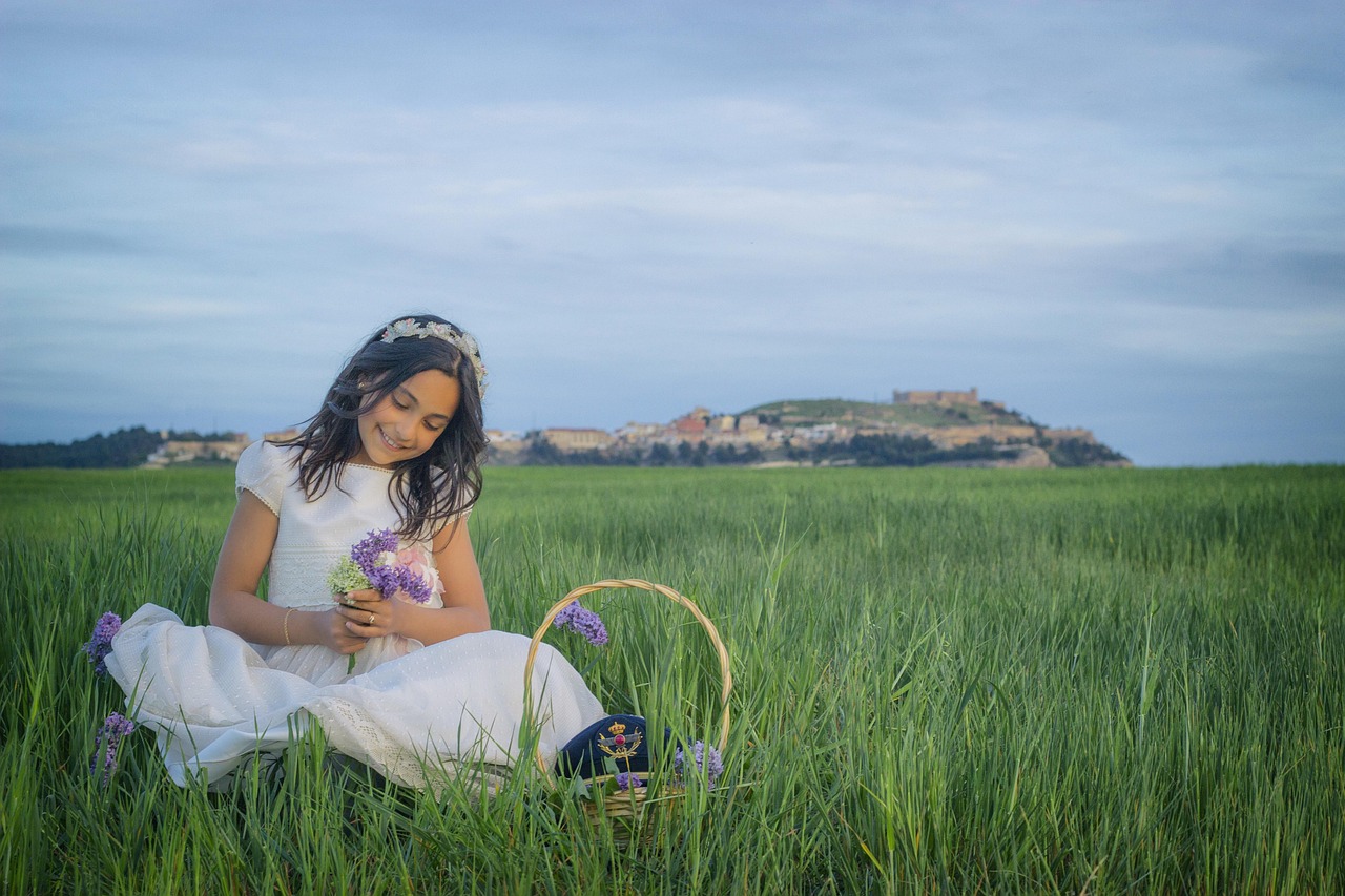 Niña en vestido de comunión disfrutando al aire libre en Valencia, símbolo de una celebración familiar con música en vivo.